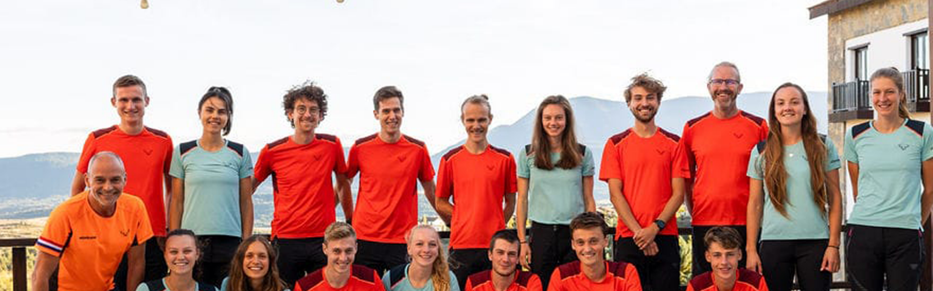 Jose met het Nederlandse team. Jose staat tussen allemaal jonge atleten op de achtergrond schijnt de zon en zie je nog net wat bergen