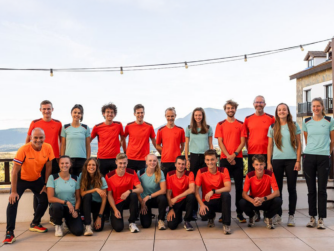 Jose met het Nederlandse team. Jose staat tussen allemaal jonge atleten op de achtergrond schijnt de zon en zie je nog net wat bergen